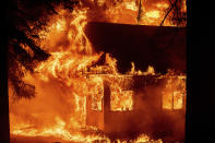 Flames consume a home as the Dixie Fire tears through the Indian Falls community in Plumas County, Calif., on Saturday, July 24, 2021. The fire destroyed multiple residences in the area. (AP Photo/Noah Berger)