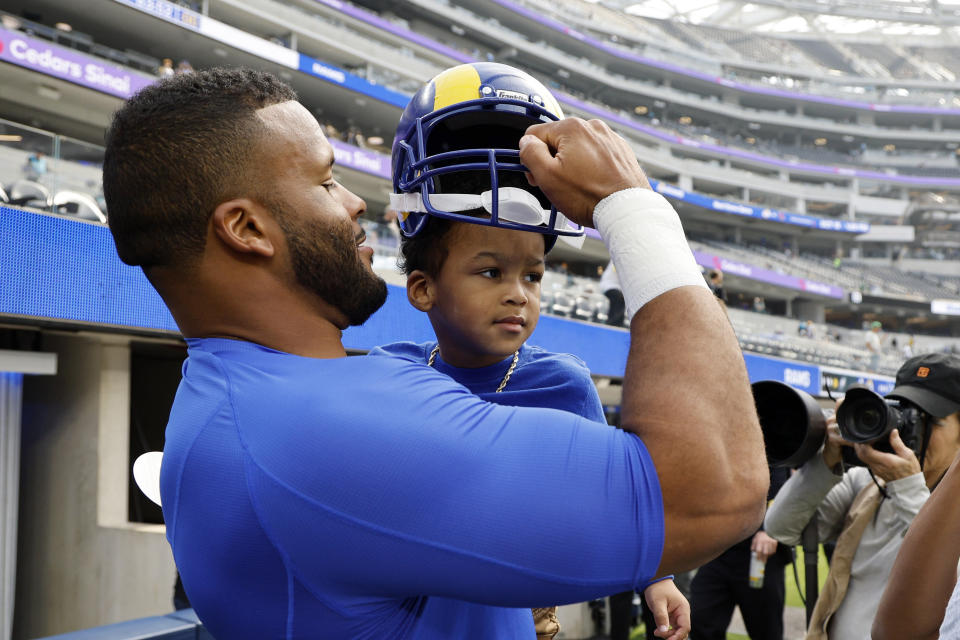 Los Angeles Rams defensive tackle Aaron Donald spends a few minutes with his son Aaric as he warms up prior to an NFL football game against the Philadelphia Eagles Sunday, Oct. 8, 2023, in Inglewood, Calif. (AP Photo/Kevork Djansezian)