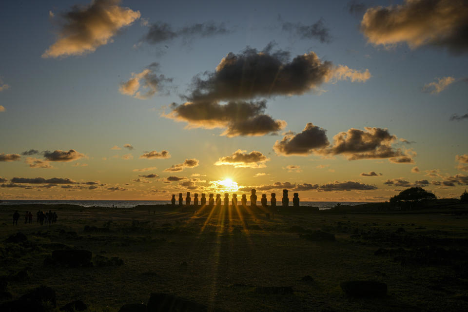 El sol sale detrás de una hilera de moais en Ahu Tongariki, Rapa Nui o Isla de Pascua, Chile, el sábado 26 de noviembre de 2022. Cada estatua monolítica tallada hace siglos por el pueblo rapanui de esta remota isla del Pacífico representa un antepasado. (Foto AP/Esteban Félix)