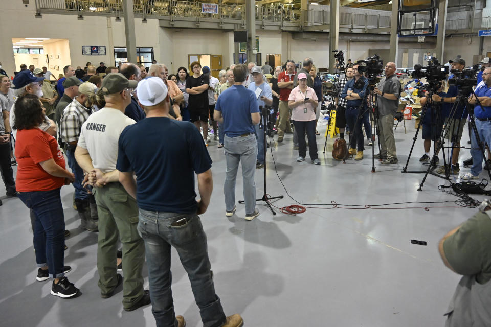 Kentucky Gov. Andy Beshear, center, speaks to the media and residents of Knott County that have been displaced by floodwaters at the Knott County Sportsplex in Leburn, Ky., Sunday, July 31, 2022. (AP Photo/Timothy D. Easley)