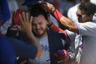 Toronto Blue Jays' Alejandro Kirk left, celebrates with teammate Santiago Espinal, right, along with other teammates in the dugout after hitting a solo home run during the third inning of a baseball game against the Chicago White Sox, Wednesday, June 22, 2022, in Chicago. (AP Photo/Paul Beaty)
