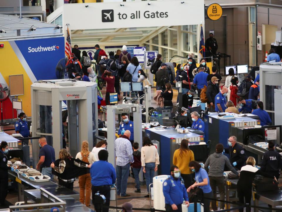 Travelers wearing protective face masks to prevent the spread of the coronavirus disease (COVID-19) go through security before boarding a flight at the airport in Denver, Colorado, U.S., November 24, 2020.