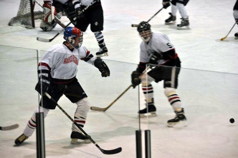 Tom Levis (left) and Glen Beyer play in an alumni hockey game.