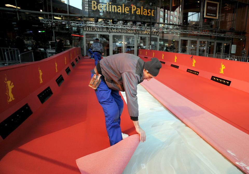 Workers lay the red carpet for the start of the Berlin International Film Festival at Potsdamer Platz in Berlin, Germany, Wednesday Feb. 5, 2014. The festival will run from Feb. 6 until Feb. 16, 2014. (AP Photo/dpa,Britta Pedersen)