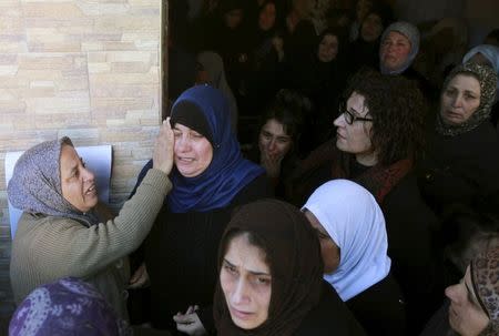 Relatives of Palestinian protester Malek Shahin, who medics said was shot dead by Israeli troops while they were carrying out an arrest raid on Tuesday, mourn during his funeral in the West Bank Deheishe Refugee Camp, south of Bethlehem December 8, 2015. REUTERS/Abdelrahman Younis