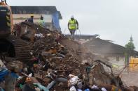 Rescue workers search for survivors in the rubble of a collapsed five-storey apartment building in Mahad. (Photo by PUNIT PARANJPE/AFP via Getty Images)