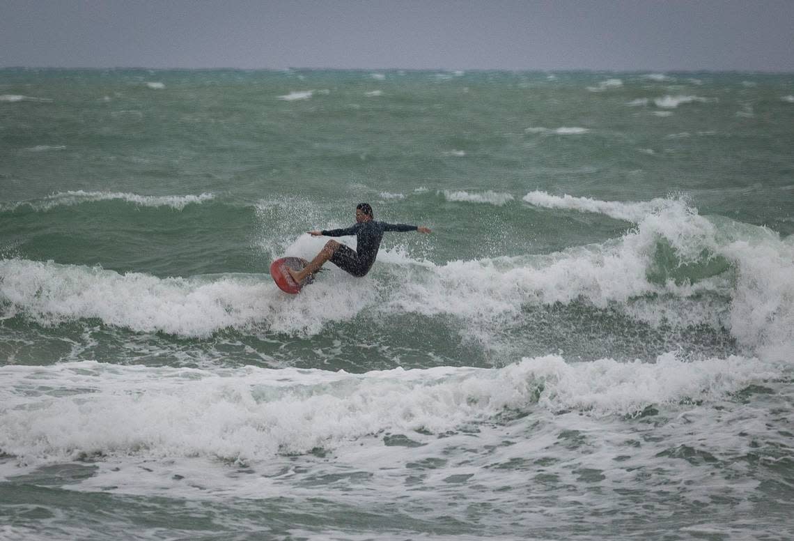 A surfer rides a wave during bad weather on Wednesday, Dec. 13, 2023, in South Miami Beach. Alie Skowronski/askowronski@miamiherald.com