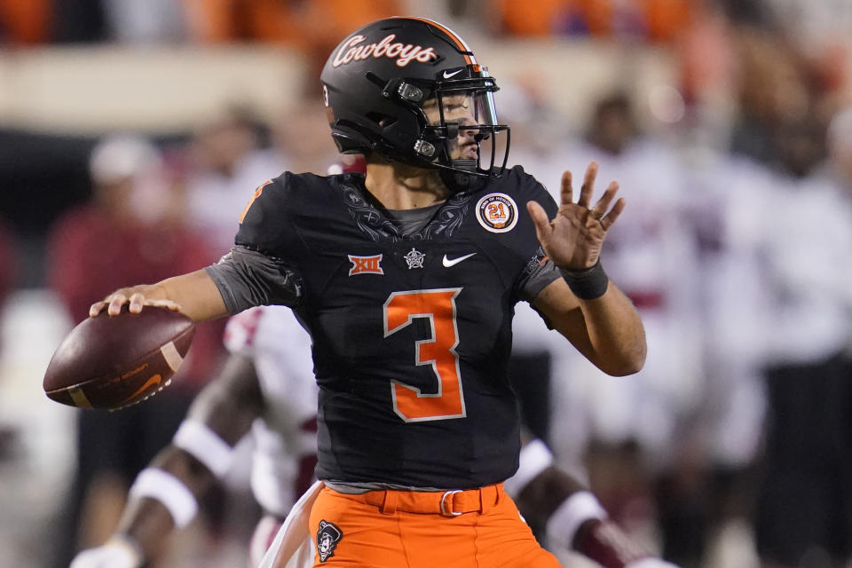 Oklahoma State quarterback Spencer Sanders looks for a receiver duriong the first half of the team's NCAA college football game against Oklahoma, Saturday, Nov. 27, 2021, in Stillwater, Okla. (AP Photo/Sue Ogrocki)