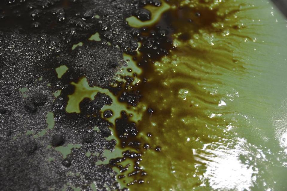 In this Nov. 17, 2016 photo provided by the Pacific Northwest National Laboratory, PNNL, oil spreads on top of water with a slushy crust. The small ice chunks bob around and push oil below the surface, which makes cleaning up oil spills in the Arctic a challenge during a demonstration of sawdust oil recovery material research at the PNNL in Richland, Wash. (Pacific Northwest National Laboratory via AP)