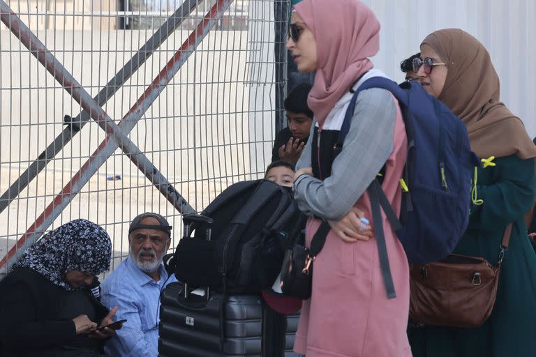 Palestinas con doble ciudadanía aguardan para cruzar a Egipto en el cruce fronterizo de Rafah (Photo by MOHAMMED ABED / AFP)