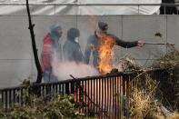 Demonstrators set fire to hay on an overpass during a demonstration of farmers near the European Council building in Brussels, Tuesday, March 26, 2024. Dozens of tractors sealed off streets close to European Union headquarters where the 27 EU farm ministers are meeting to discuss the crisis in the sector which has led to months of demonstrations across the bloc. (AP Photo/Geert Vanden Wijngaert)