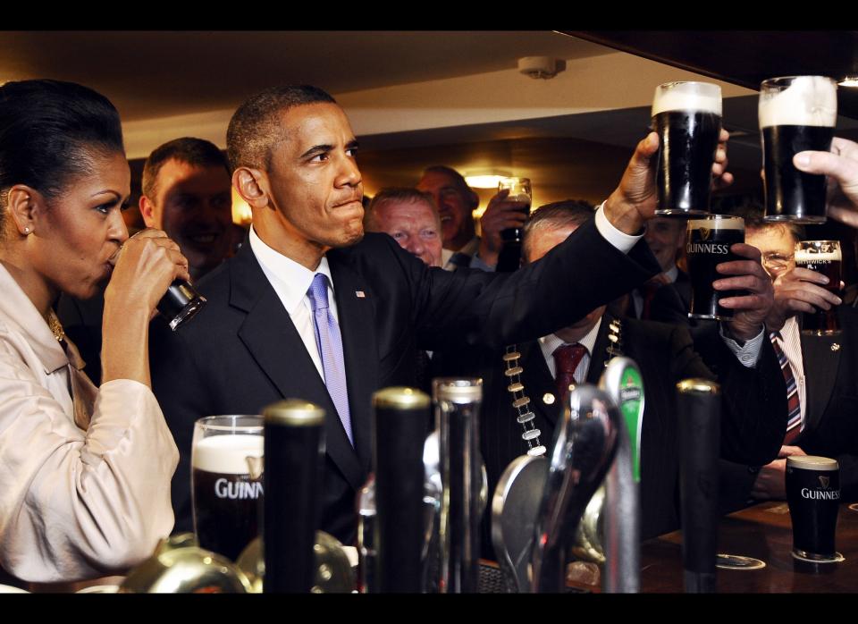 The Obamas sip Guinness at a pub as they visit Moneygall village in rural County Offaly, Ireland, where the President's great-great-great grandfather Falmouth Kearney hailed from, on May 23, 2011. Obama landed in Ireland on May 23, 2011 for a visit celebrating his ancestral roots, kicking off a four-nation European tour. AFP PHOTO/ JEWEL SAMAD