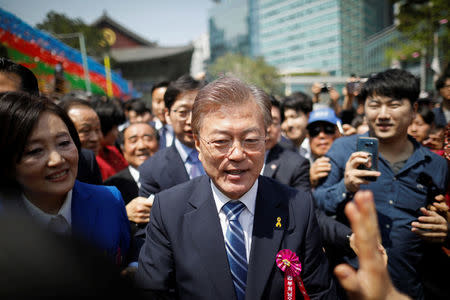 Moon Jae-in, presidential candidate of the Democratic Party of Korea, is surrounded by supporters as he leaves after attending a ceremony celebrating the birthday of Buddha at Jogye temple in Seoul, South Korea, May 3, 2017. REUTERS/Kim Hong-Ji