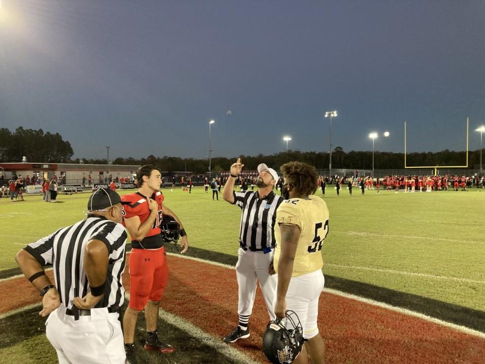 Captains for Gainesville Buchholz and Creekside meet at midfield for the coin flip before the teams' 2020 game, a Buchholz victory.