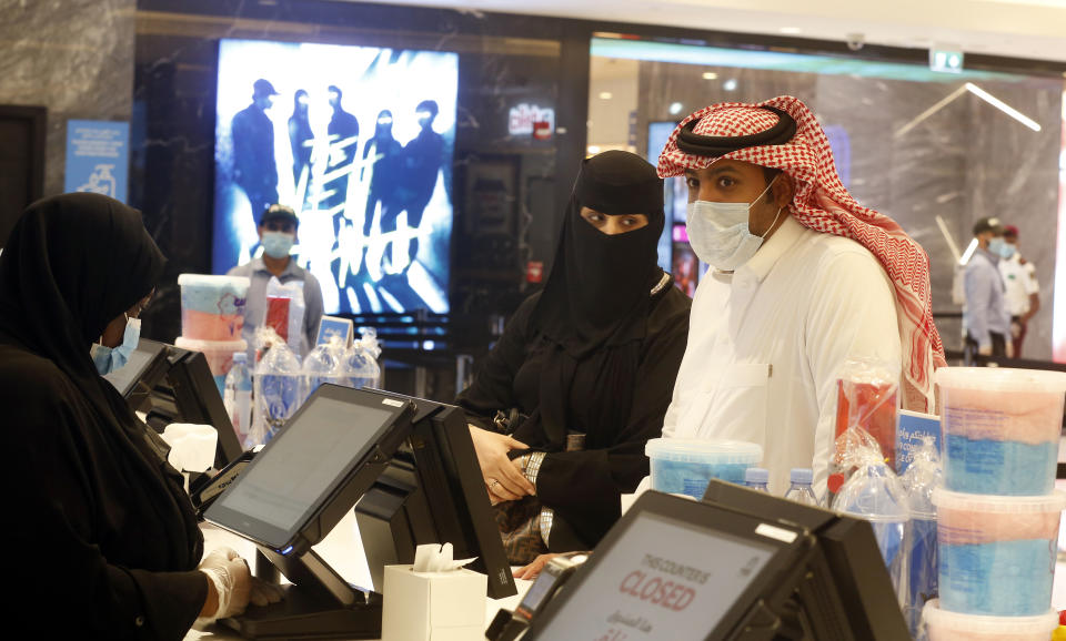 Saudi movie viewers wear face masks to help curb the spread of the coronavirus, as they buy refreshments at VOX Cinema hall in Jiddah, Saudi Arabia, Friday, June 26, 2020, after the announcement of easing of lockdown measures amid the coronavirus outbreak. (AP Photo/Amr Nabil)