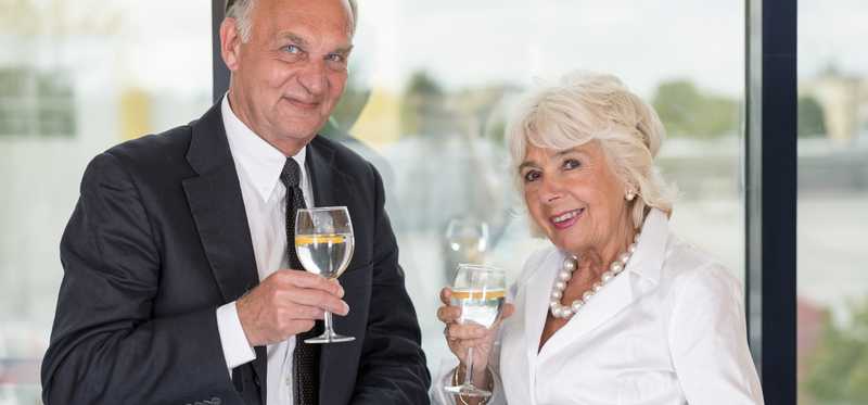 Senior couple holding champagne glasses.