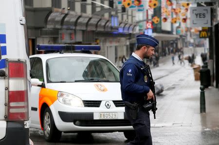 A Belgian police officer patrols near a central Brussels shopping centre after a man was arrested with hoax explosive belt, Belgium, June 21, 2016. REUTERS/Francois Lenoir