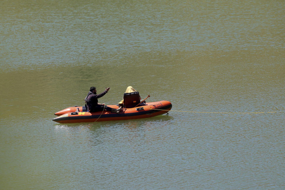 Investigators on a boat use a camera to search for a body in a lake near Xiliatos, after authorities found two female bodies in a flooded mineshaft, outside of Mitsero village, near capital Nicosia, Cyprus, Monday, April 22, 2019. Police on the east Mediterranean island nation, along with the help of the fire service, are conducting the search Monday in the wake of last week's discovery of the bodies in the abandoned mineshaft and the disappearance of the six year-old daughter of one of the victims. (AP Photo/Philippos Christou)