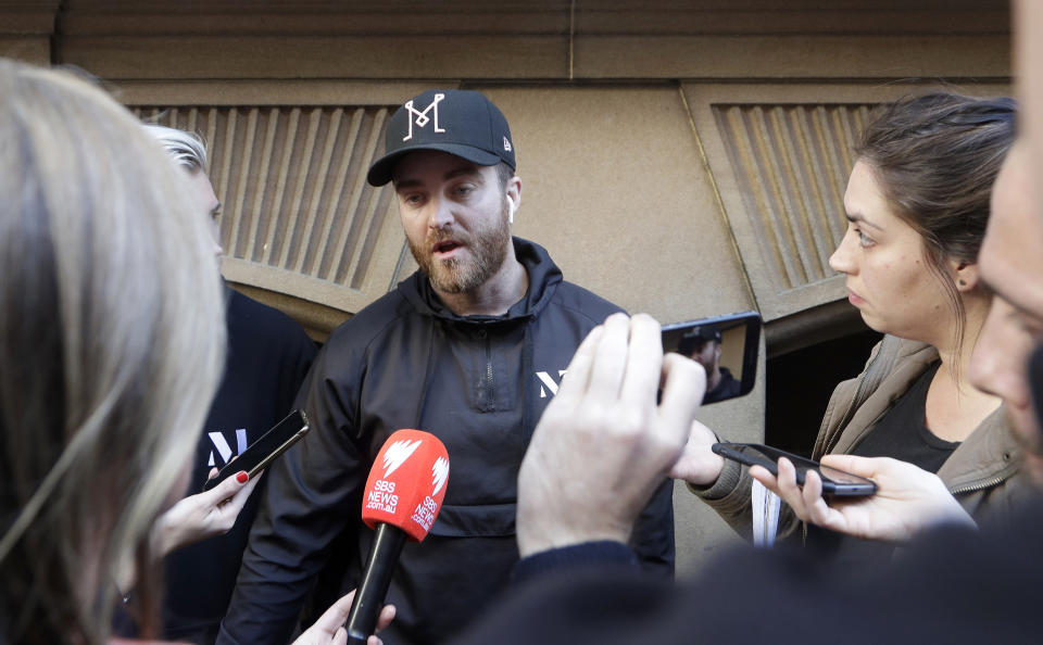 Paul O'Shaughnessy, center, tells how he and his brother Luke chased down a man who attempted to stab multiple people in Sydney, Australia, Tuesday, Aug. 13, 2019. Police and witnesses say a knife-wielding man yelling "Allahu akbar," or "God is great," has attempted to stab several people before being arrested, with one person taken to a hospital. (AP Photo/Rick Rycroft)