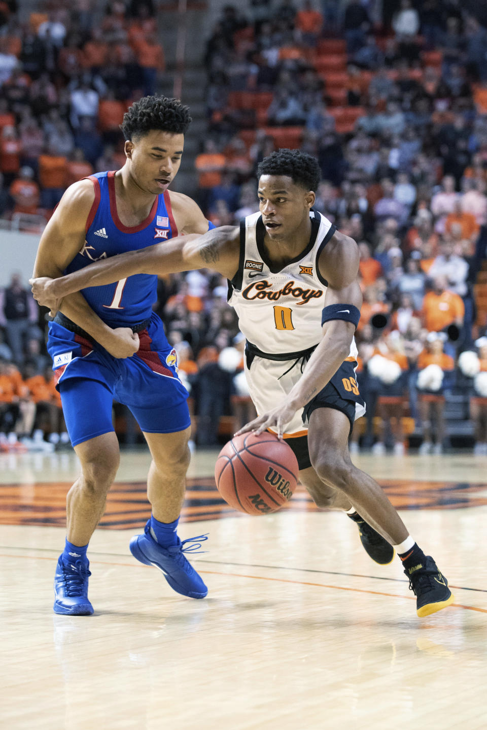 Oklahoma State guard Avery Anderson III (0) drives past Kansas guard Devon Dotson (1) during the first half of an NCAA college basketball game in Stillwater, Okla., Monday, Jan. 27, 2020. (AP Photo/Brody Schmidt)