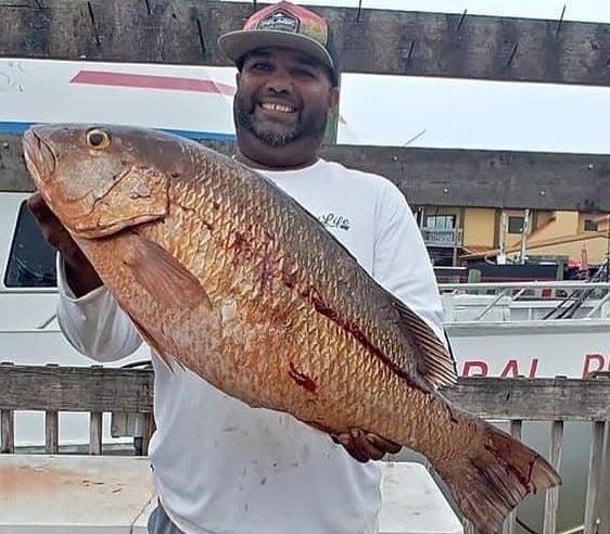 A customer of Canaveral Princess hoists a 14-pound mangrove snapper he caught June 19, 2022.