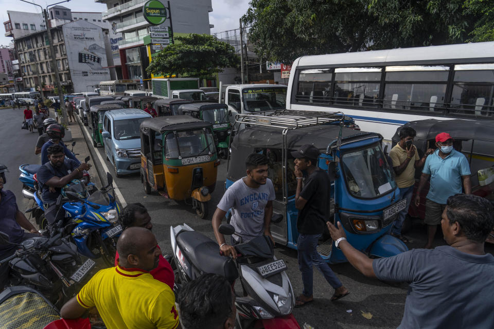 FILE - Sri Lankans wait in queue to buy petrol at a fuel station, in Colombo, Sri Lanka, July 17, 2022. The Asian Development Bank has downgraded its forecasts for growth in the region, citing the war in Ukraine, rising interest rates aimed at fighting decades-high inflation and China's slowing economy. (AP Photo/Rafiq Maqbool, File)