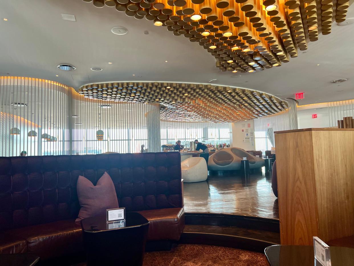 Inside the Virgin Atlantic lounge at JFK with purple and beige chairs and gold ceiling decoration.