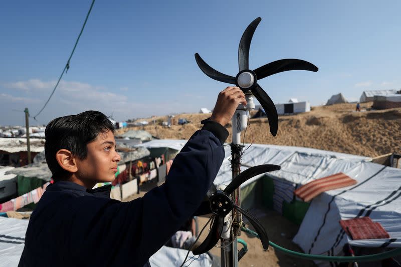 Displaced 'Gaza Newton' lights up his tent with wind energy amid power cut