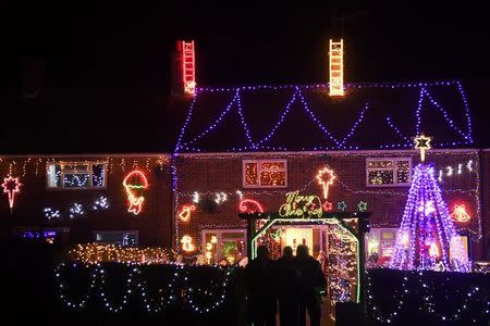 Visitors and locals view Christmas displays on dozens of properties that have been decorated in thousands of lights in a tradition that has grown over recent years in the small village of Westfield in Sussex, south east England, December 15, 2016. Picture taken on December 15. REUTERS/Toby Melville