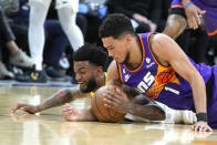 Utah Jazz guard Nickeil Alexander-Walker and Phoenix Suns guard Devin Booker (1) fight for the loose ball during the first half of an NBA basketball game, Saturday, Nov. 26, 2022, in Phoenix. (AP Photo/Rick Scuteri)