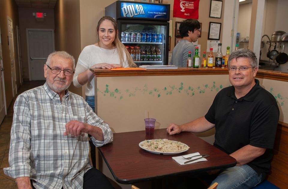 In Northborough, Hillside Grill owner Dimitrios Voyiatzis with daughter Abbygaile Kieler and customer Dan Lambert, of Shrewsbury, with chicken, broccoli alfredo pasta dish,  Oct. 13, 2022.