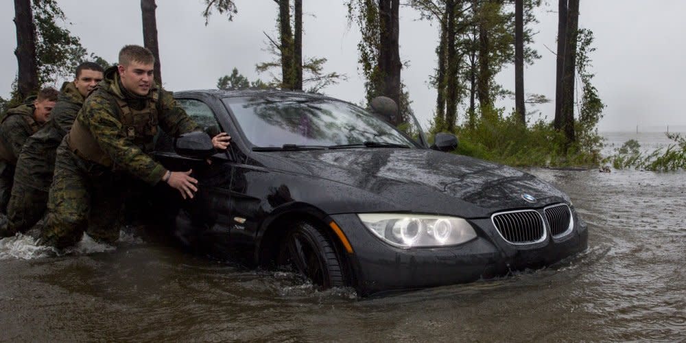 Marines with Marine Corps Base Camp Lejeune help push a car out of a flooded area during Hurricane Florence, on Marine Corps Base Camp Lejeune, Sept. 15, 2018.