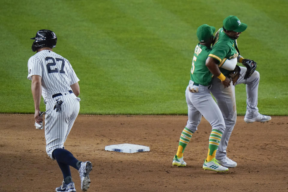 Oakland Athletics' Tony Kemp (5) hugs Elvis Andrus as New York Yankees' Giancarlo Stanton (27) leaves the field after a baseball game Friday, June 18, 2021, in New York. The Athletics won 5-3. (AP Photo/Frank Franklin II)