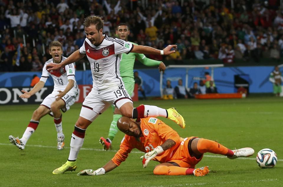 Algeria's goalkeeper Rais Mbolhi saves the ball beside Germany's Mario Goetze (C) and Thomas Mueller (L) during their 2014 World Cup round of 16 game at the Beira Rio stadium in Porto Alegre June 30, 2014. REUTERS/Edgard Garrido