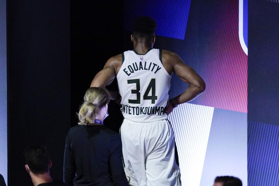 Milwaukee Bucks' Giannis Antetokounmpo leaves the court after hurting his ankle during the first half of an NBA conference semifinal playoff basketball game against the Miami Heat Sunday, Sept. 6, 2020, in Lake Buena Vista, Fla. (AP Photo/Mark J. Terrill)