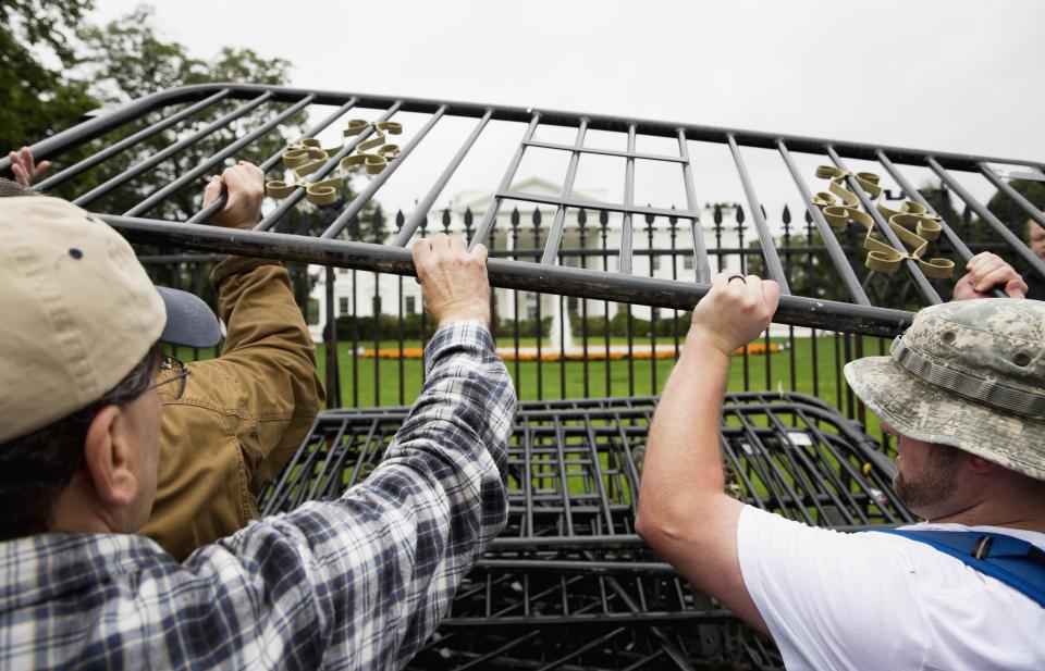 Protesters taking part in the "Million Vet March on the Memorials" pile barracades in front of the White House in Washington October 13, 2013. The group was organized in protest of the Obama administration's decision to close the memorial and bar entry to World War Two vets who had traveled to visit it during the partial government shut down. REUTERS/Joshua Roberts (UNITED STATES - Tags: POLITICS BUSINESS EMPLOYMENT MILITARY TPX IMAGES OF THE DAY CIVIL UNREST)