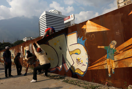 Opposition supporters enter a construction site to pick up rocks during a clash with security forces in a rally against Venezuela's President Nicolas Maduro in Caracas. REUTERS/Carlos Garcia Rawlins