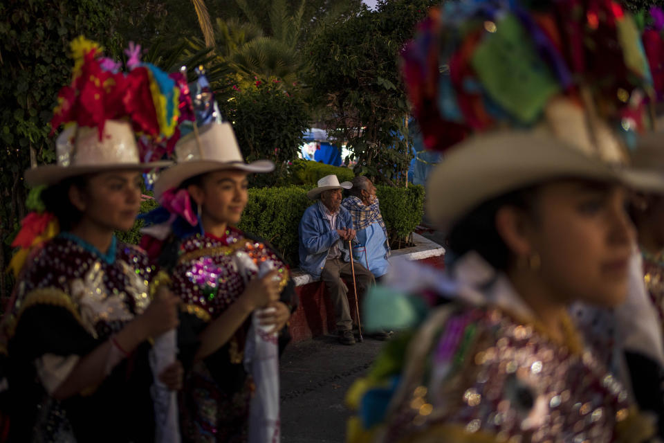 Abel Aguilar, en el centro a la izquierda, asiste a la celebración que conmemora el nacimiento del volcán Paricutín, en San Juan Nuevo Parangaricutiro, México, el lunes 20 de febrero de 2023. Aguilar tenía cinco años cuando el Paricutín entró en erupción por primera vez y fue junto con otros niños a “a ver caminar la lava, así, de a poquito”, dijo. (AP Foto/Eduardo Verdugo)