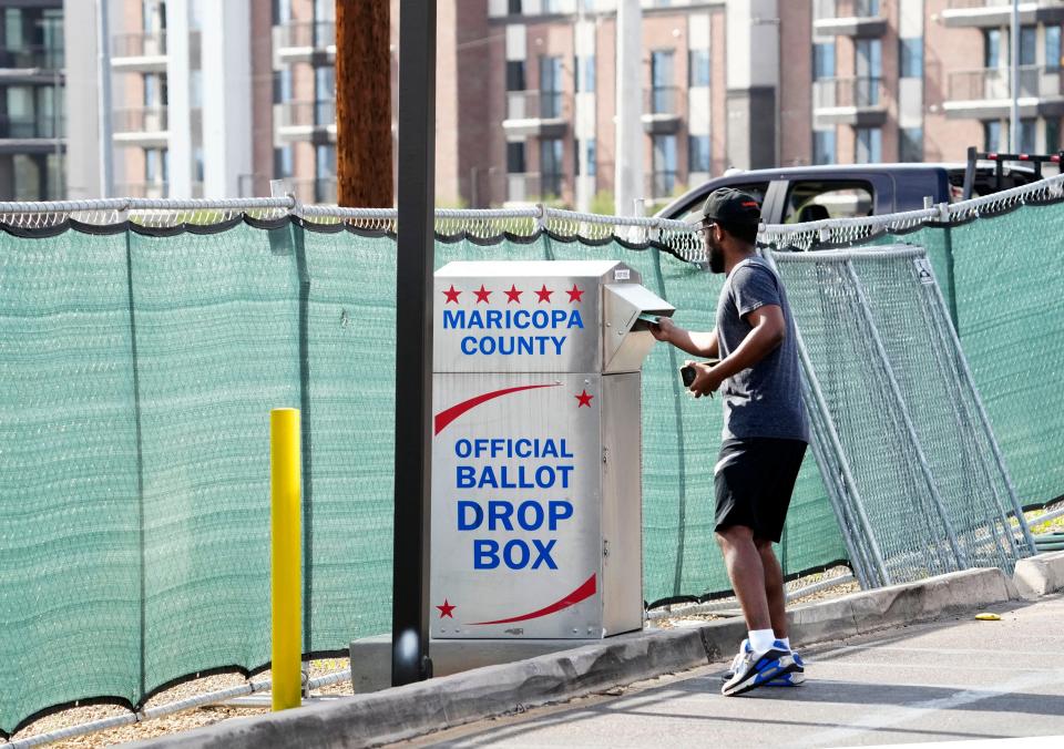 A voter delivers his ballot to a drop box at the Maricopa County Tabulation and Election Center in downtown Phoenix on Nov. 7, 2022.