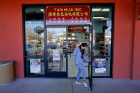 In this Feb. 13, 2020, photo, shop owner Rong Chan Tan opens her store in the Mekong Plaza in the Asian district, in Mesa, Ariz. The Asian district is trying to gain a cultural foothold in the community that previously had little Asian presence but the coronavirus outbreak in China has been impacting business in Mesa and throughout the U.S. (AP Photo/Matt York)