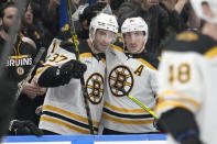 Boston Bruins center Patrice Bergeron (37) celebrates with left wing Brad Marchand (63) after Bergeron assisted on Marchand's goal during the second period of an NHL hockey game against the Tampa Bay Lightning Monday, Nov. 21, 2022, in Tampa, Fla. (AP Photo/Chris O'Meara)