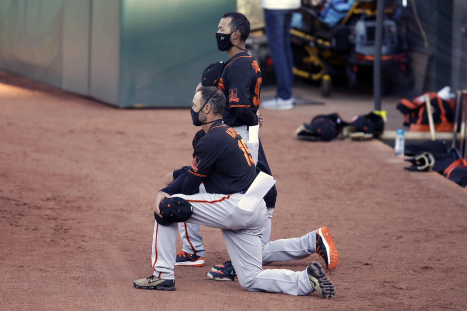 San Francisco Giants' manager Gabe Kapler kneels during the national anthem prior to an exhibition baseball game against the Oakland Athletics, Monday, July 20, 2020, in Oakland, Calif. (AP Photo/Ben Margot)