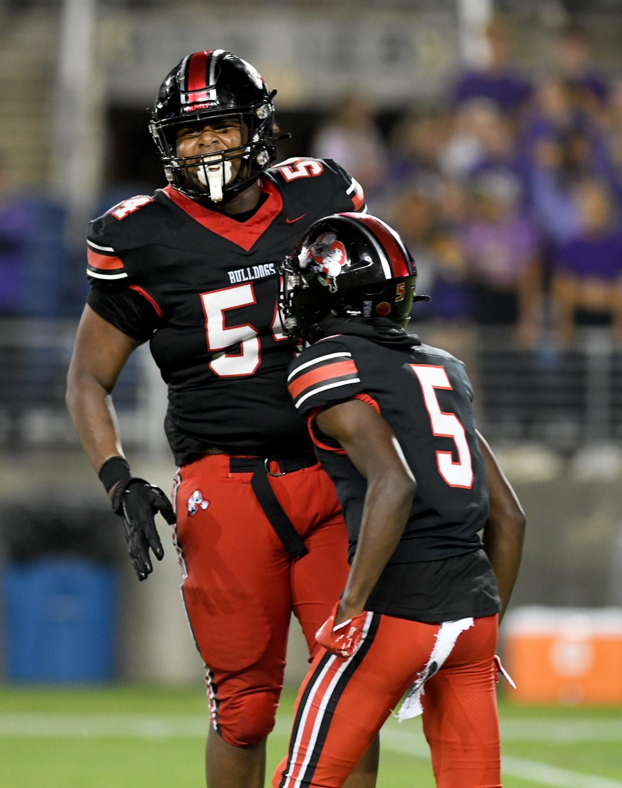 McKinley's Dior Garner (left) and Jordan McElroy (5) celebrate a play against Avon during a high school football game, Friday, Aug. 25, 2023.