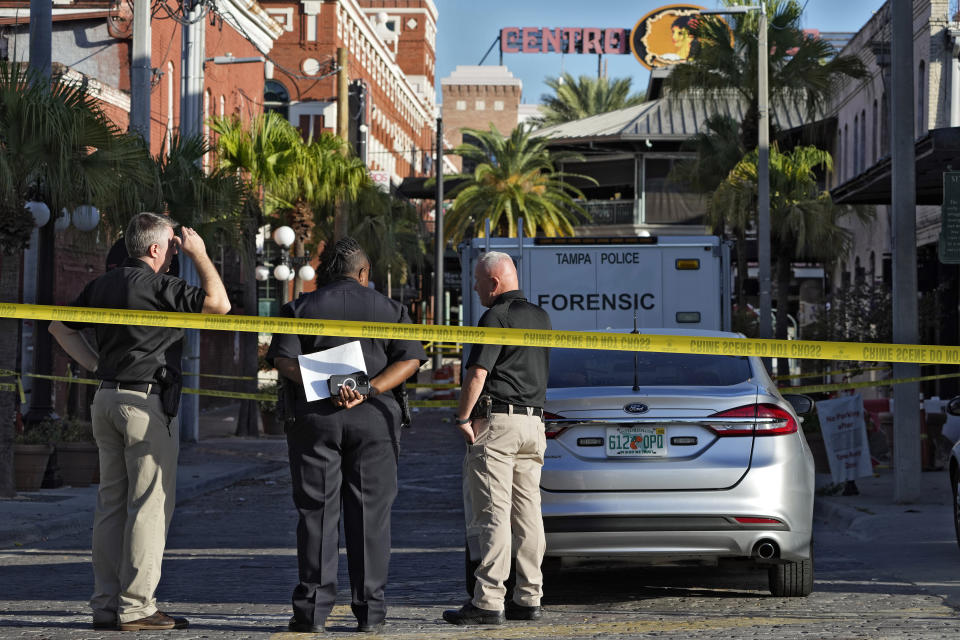 Tampa police officers stand in the street in the Ybor City section of Tampa, Fla., after a shooting Sunday, Oct. 29, 2023. A fight between two groups turned deadly in a shooting during Halloween festivities. (AP Photo/Chris O'Meara)