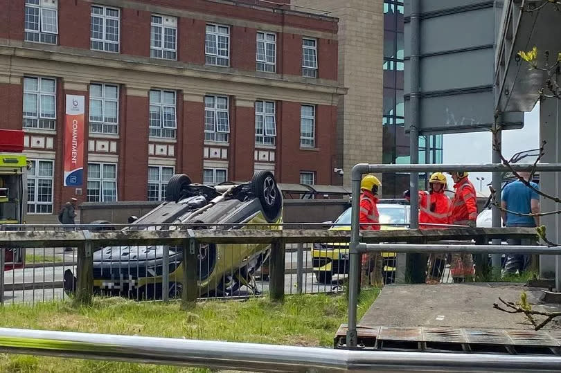 The car ploughed into a barrier before landing on its roof outside the Bury College campus