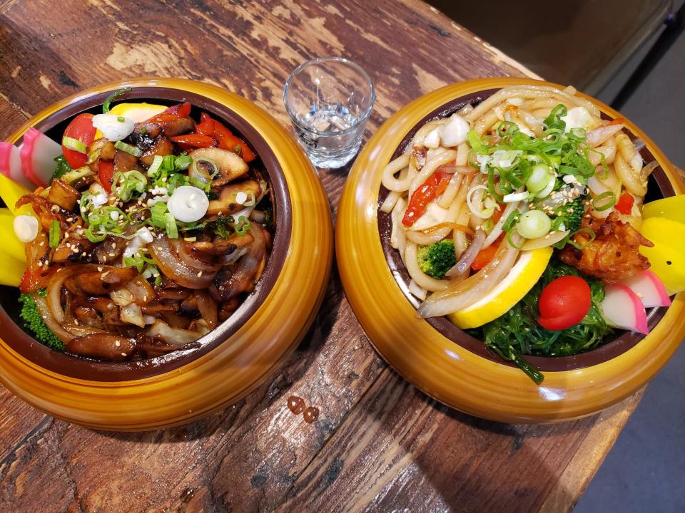 Bento meals are served in bowls at Den Den Cafe Asiana in Providence. A mushroom and onion dish is at left, and an Udon noodle one is at right.