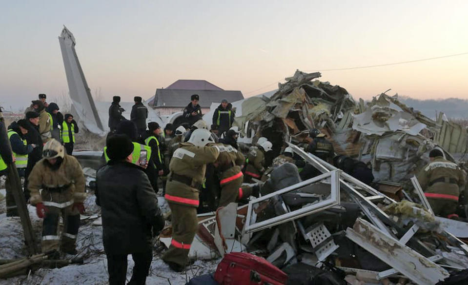 In this handout photo provided by the Emergency Situations Ministry of the Republic of Kazakhstan, police and rescuers work on the side of a plane crash near Almaty International Airport, outside Almaty, Kazakhstan, Friday, Dec. 27, 2019. Almaty International Airport said a Bek Air plane crashed Friday in Kazakhstan shortly after takeoff causing numerous deaths. The aircraft had 100 passengers and crew onboard when hit a concrete fence and a two-story building shortly after takeoff. ( Emergency Situations Ministry of the Republic of Kazakhstan photo via AP)