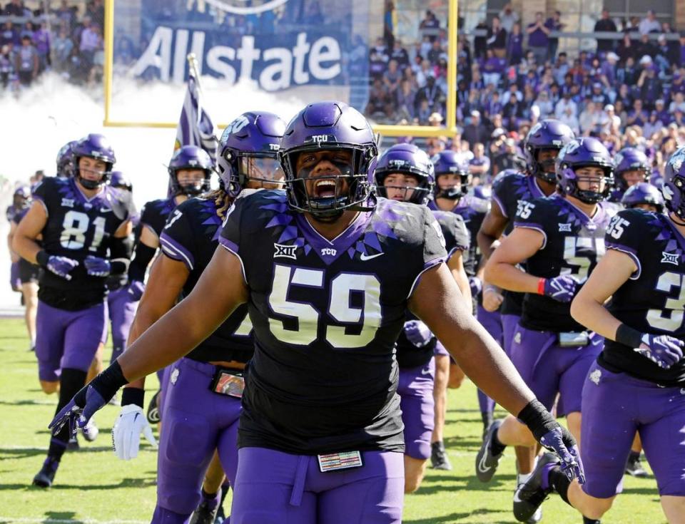 TCU defensive lineman Tico Brown (59) and the rest of the Horned Frogs enter the field prior to a 2023 season.
