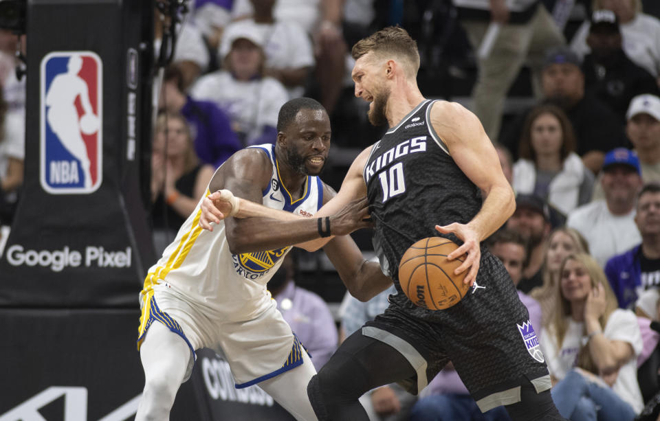 Golden State Warriors forward Draymond Green defends Sacramento Kings forward Domantas Sabonis