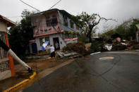 A man walks close to damaged houses after the area was hit by Hurricane Maria in Guayama, Puerto Rico September 20, 2017. REUTERS/Carlos Garcia Rawlins